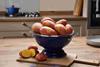 A colander of red and white potatoes on a kitchen countertop