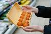 Woman chooses chicken eggs in a grocery store. Close up - Getty Images