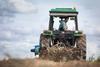Farmer on tractor harvesting organic potatoes