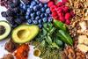 Multi colored vegetables, fruits, legumes, nuts and spices on wooden table