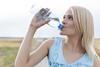 Blonde woman drinking bottled water