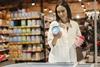 Image of woman in store choosing between ice cream pints.