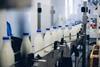milk bottles on conveyer- getty