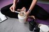 Woman scooping whey powder into shake