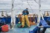 Fisherman inspecting trawl net on research ship