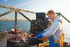 Fisherman at work on boat - Getty Images
