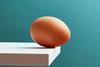 An egg teetering on the edge of a plank - stock photo - Getty Images