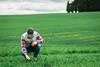 Farmer checking crops in lush green agricultural field