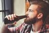 Bearded hipster drinking from a beer bottle