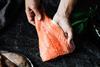 Close-up of a chef preparing fresh salmon fillet in kitchen