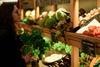 Woman selecting fresh vegetables at a market stall filled with diverse produce - stock photo - Getty Images