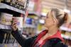 Shopper looks at labelling on tin on shelf