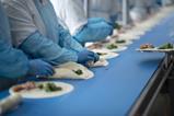 Greencore - Workers make wraps on a production line at a Greencore factory