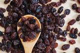 Raisins on a wooden spoon