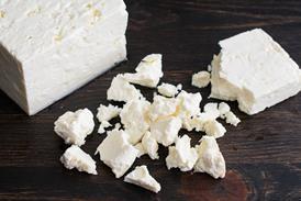 Crumbling a Block of Feta Cheese - stock photo