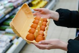 Woman chooses chicken eggs in a grocery store. Close up - Getty Images