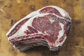 Raw prime rib of beef on a chopping board - stock photo