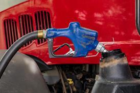 Diesel fuel nozzle fueling farm tractor. Farming input costs, fuel price increase and emissions pollution concept