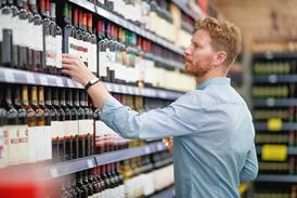 Man choosing wine bottle from shelf