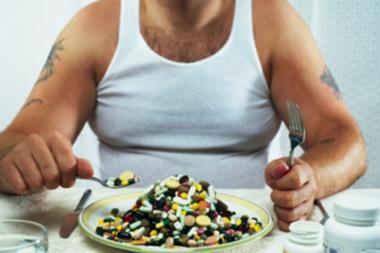 overweight man eating pills