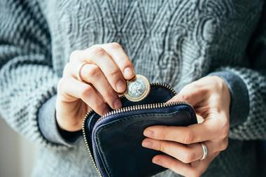 Woman putting coins into a purse_living wage_money
