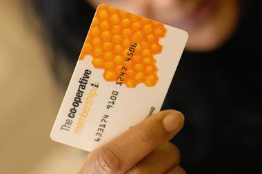 co-op employees voting at agm, woman holding co-op card