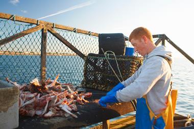 Fisherman at work on boat - Getty Images