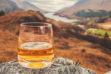 Glass of single malt Scotch Whisky on an old rock above Glenfinnan in the West Highlands of Scotland.