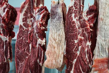 Rows of raw beef hanging in a butcher shop, ready to be cut and sold - Getty Images