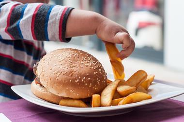 child eating burger and chips