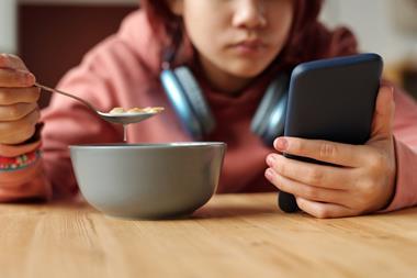 child eating phone social media advertising kids children