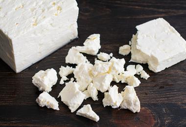 Crumbling a Block of Feta Cheese - stock photo
