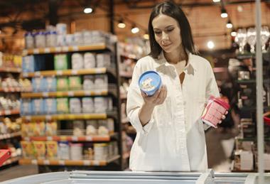 Image of woman in store choosing between ice cream pints.