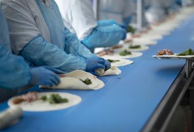 Greencore - Workers make wraps on a production line at a Greencore factory