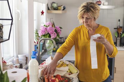 Getty woman going through her receipts at home after buying groceries