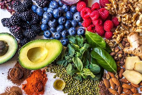 Multi colored vegetables, fruits, legumes, nuts and spices on wooden table