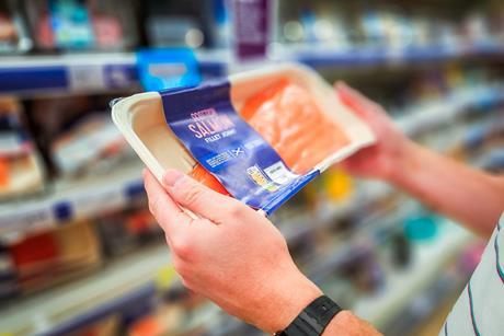 man holding scottish salmon in supermarket - getty