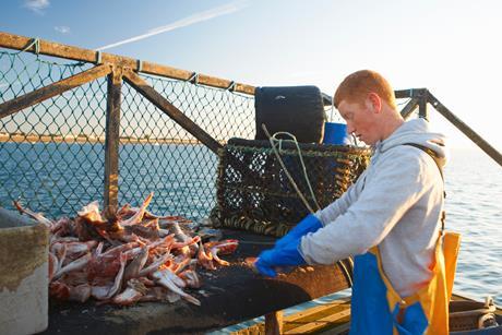 Fisherman at work on boat - Getty Images