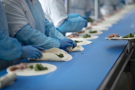 Greencore - Workers make wraps on a production line at a Greencore factory