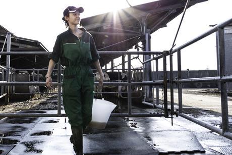 dairy farm worker with bucket - getty