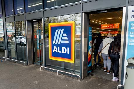 he entrance and exit of a branch of Aldi grocery supermarket with the company name sign and logo in the middle