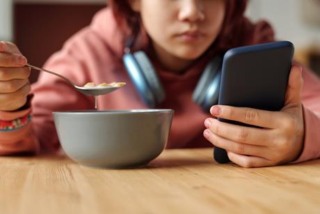child eating phone social media advertising kids children