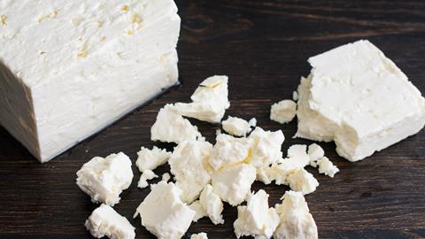 Crumbling a Block of Feta Cheese - stock photo