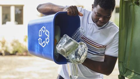 Man Emptying Household Recycling Into Green Bin Getty