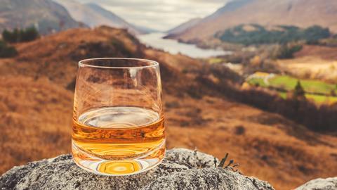 Glass of single malt Scotch Whisky on an old rock above Glenfinnan in the West Highlands of Scotland.