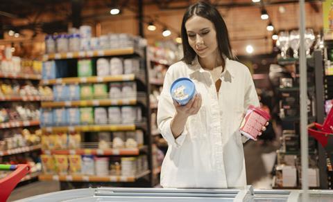Image of woman in store choosing between ice cream pints.