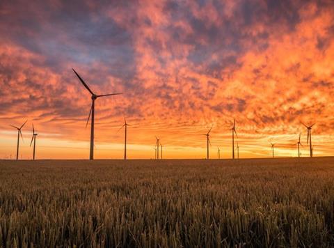 wind turbines field crops environment sunset