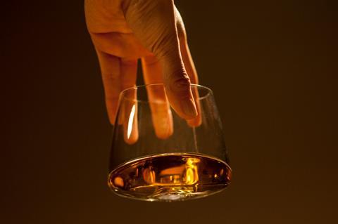 hand holding glass of whisky
