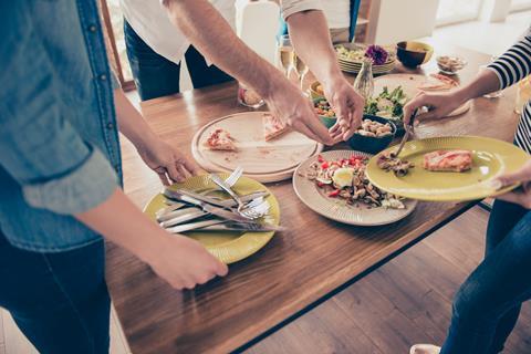 friends clearing dinner table food waste