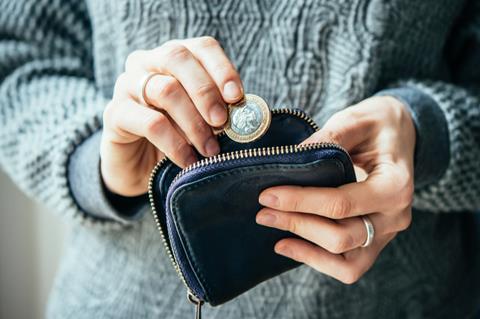 Woman putting coins into a purse_living wage_money